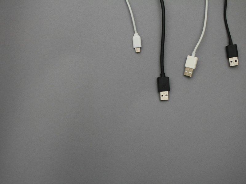 Black and white USB cables laid flat on a gray surface