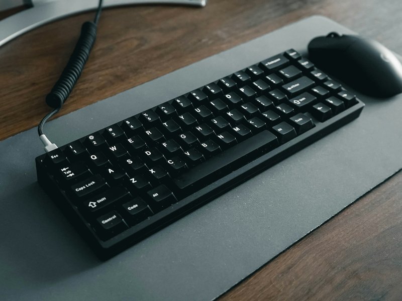 Black keyboard and mouse on a gray desk mat