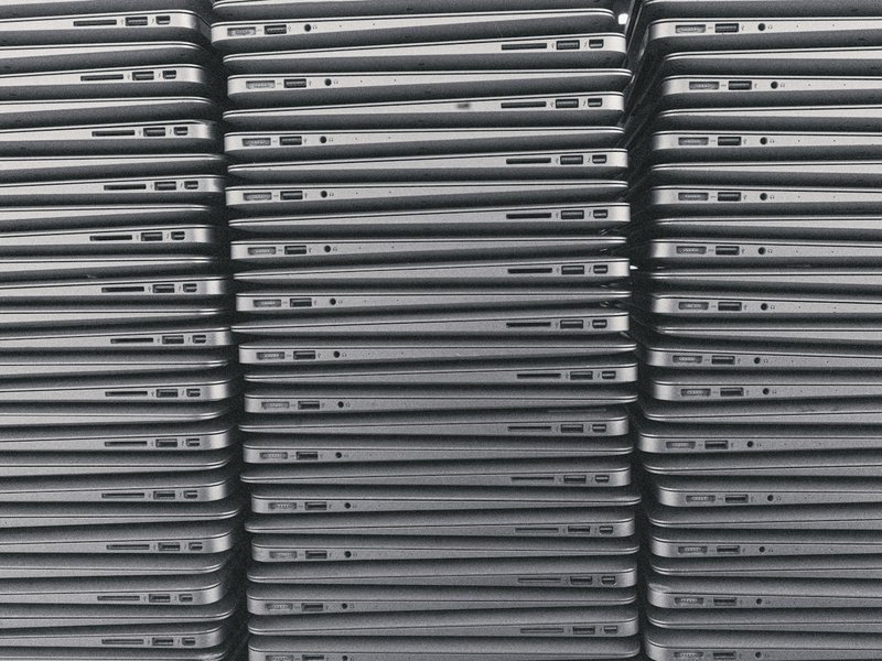 Stack of closed gray laptops seen edge-on