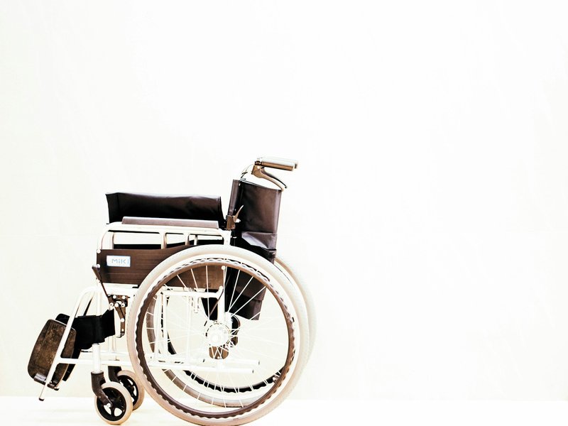 Folding manual wheelchair against a white background