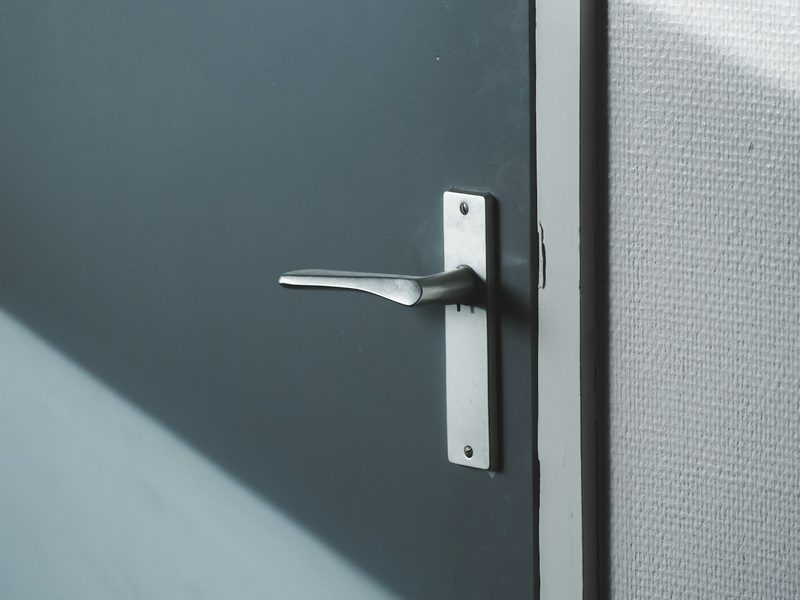 Metal lever handle on a gray commercial door