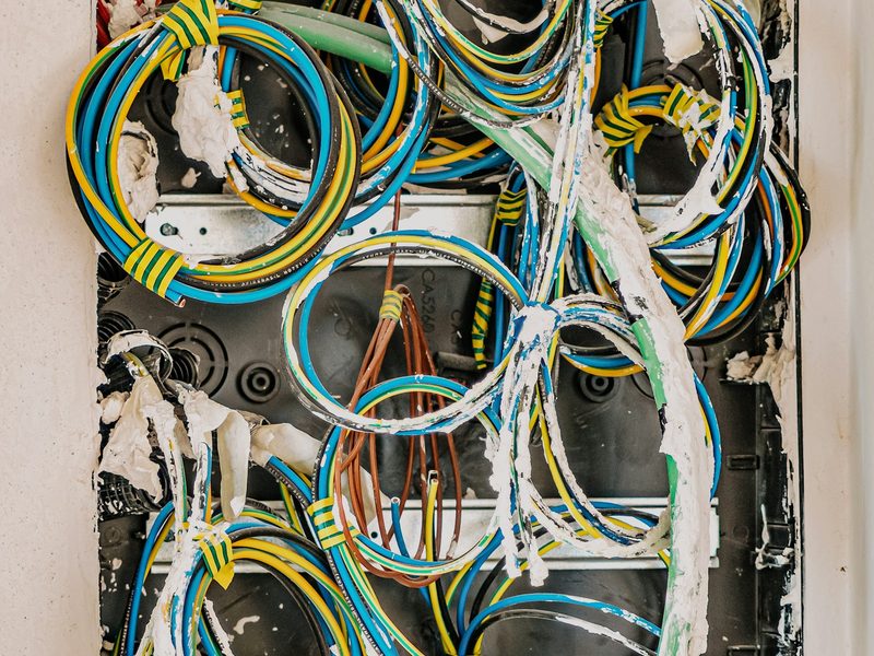 Bundled blue, yellow and black electrical wires in a wall panel