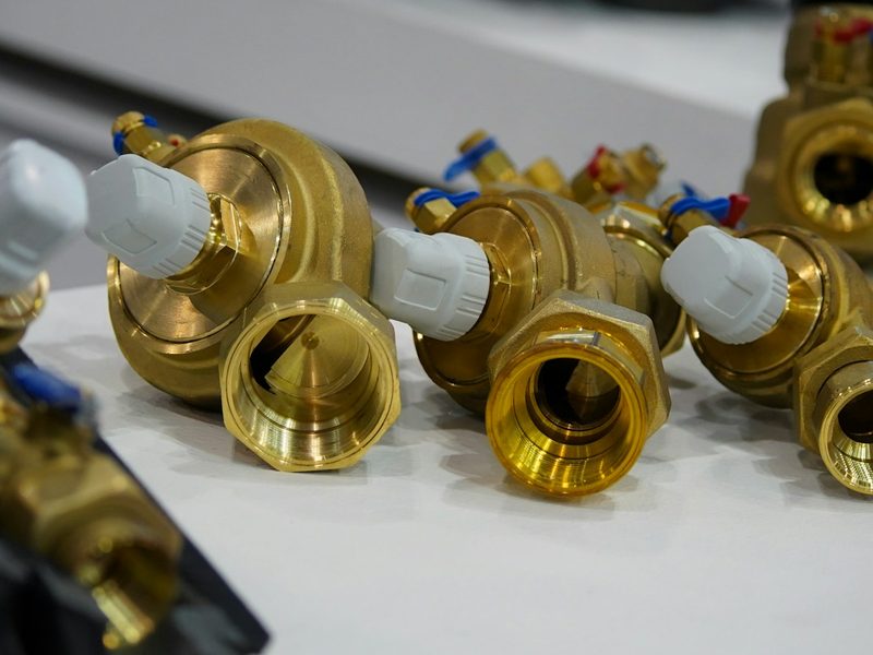 Brass valves and pipe fittings on a white surface